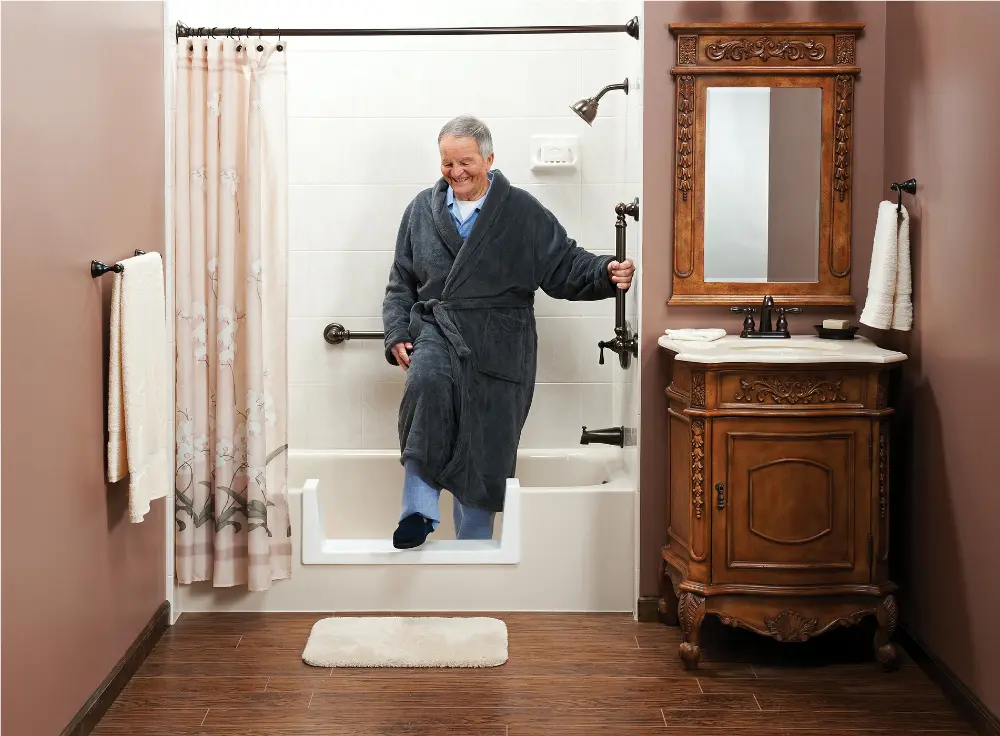 elderly man in a robe using a low barrier to exit a shower