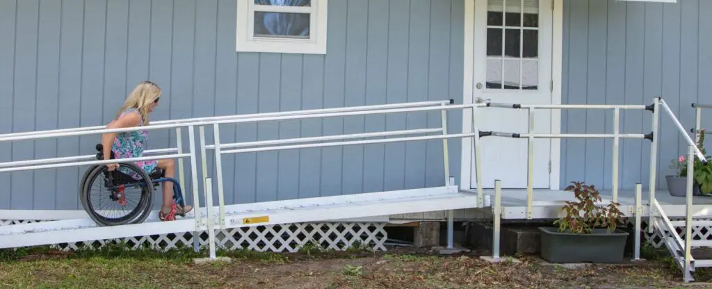 woman in a wheelchair going up a home ramp.