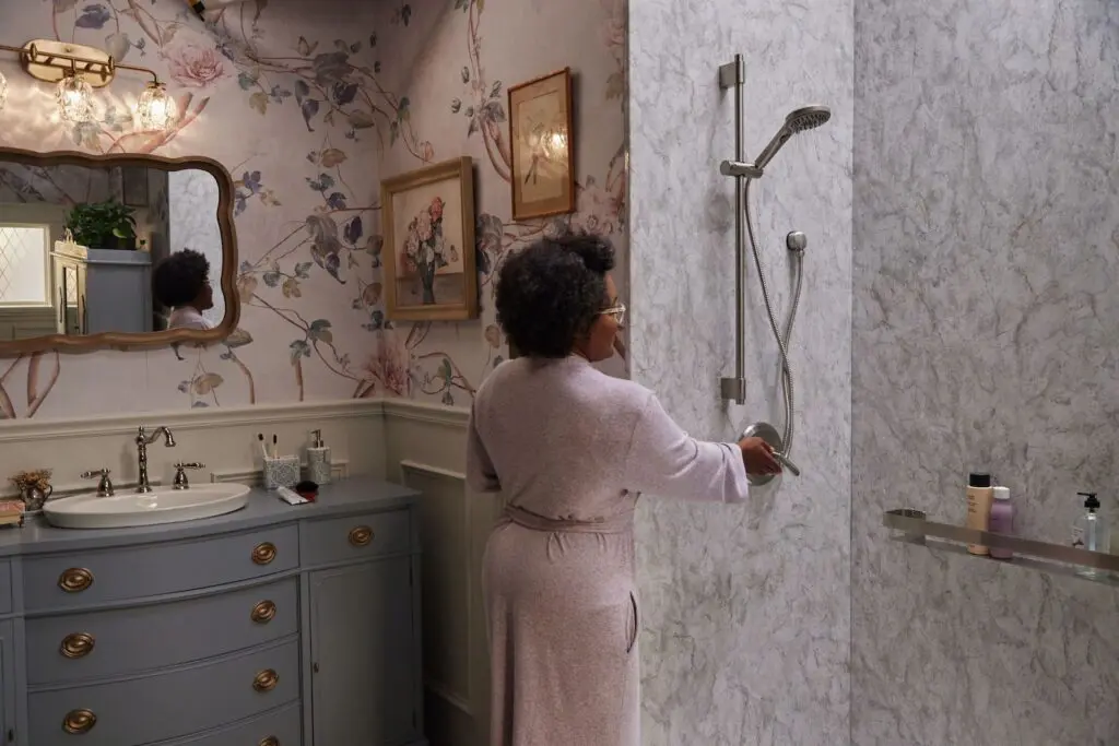 Woman walking into her standing shower.