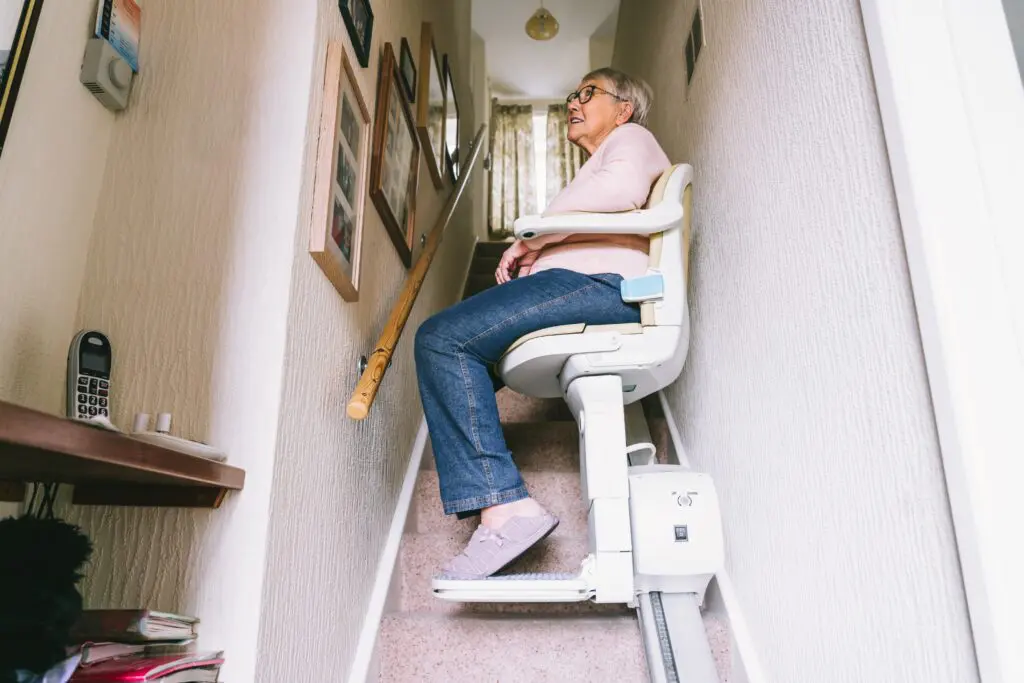 Elderly woman using automatic stairlift for fall prevention