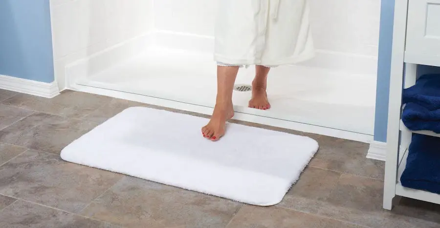 Senior entering a walk-in shower with grab bars for added stability