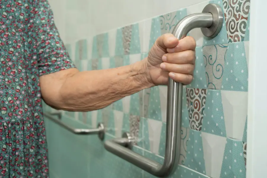 Senior using a securely installed shower grab bar for stability
