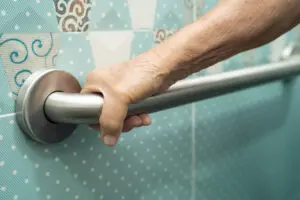 Elderly woman using shower grab bar for safety